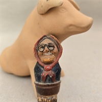 vinprop-gammel-kone-sorte-briller-roed-hovedtoerklaede-traeudskaeringgammel-prop